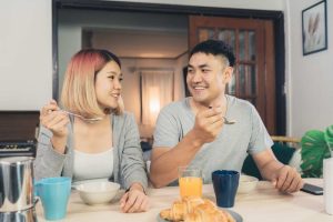 A young couple is eating breakfast