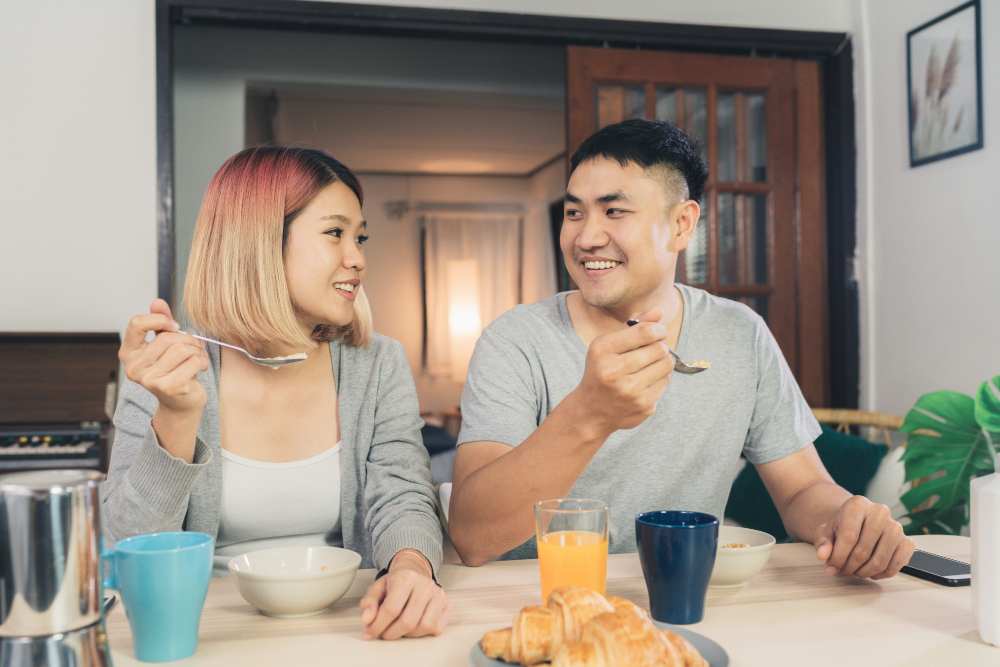 A young couple is eating breakfast